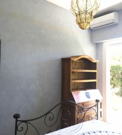 Décoration d'un mur avec secrétaire en bois, d'une chambre en badigeons de chaux gris